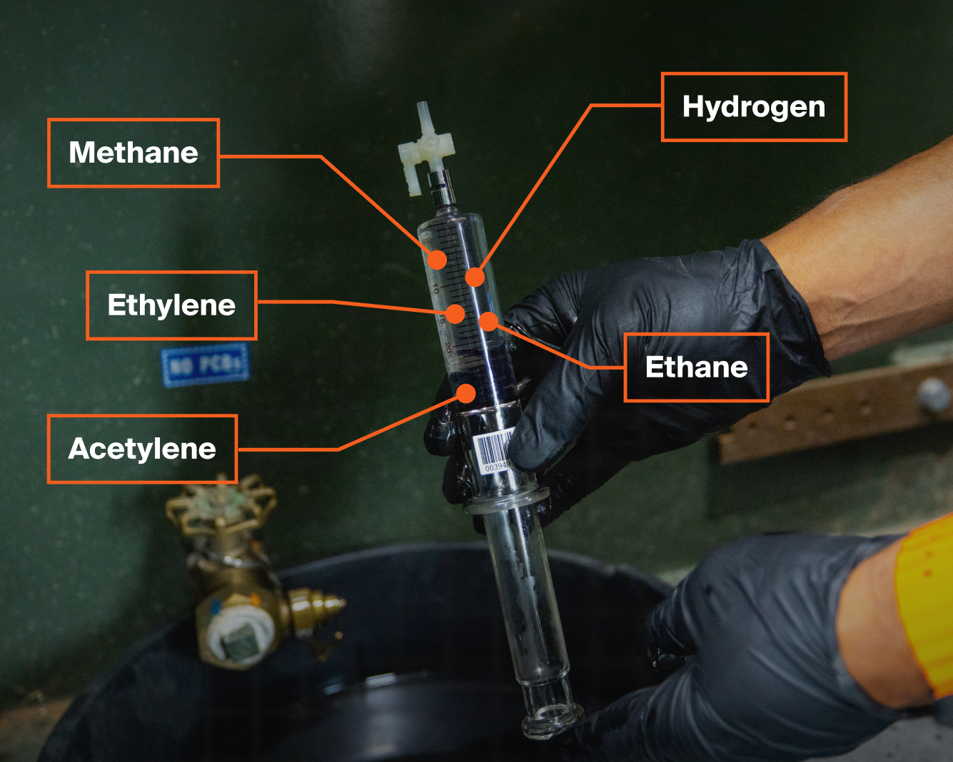 A transformer technician holding up a padmount oil sample before it is DGA tested.